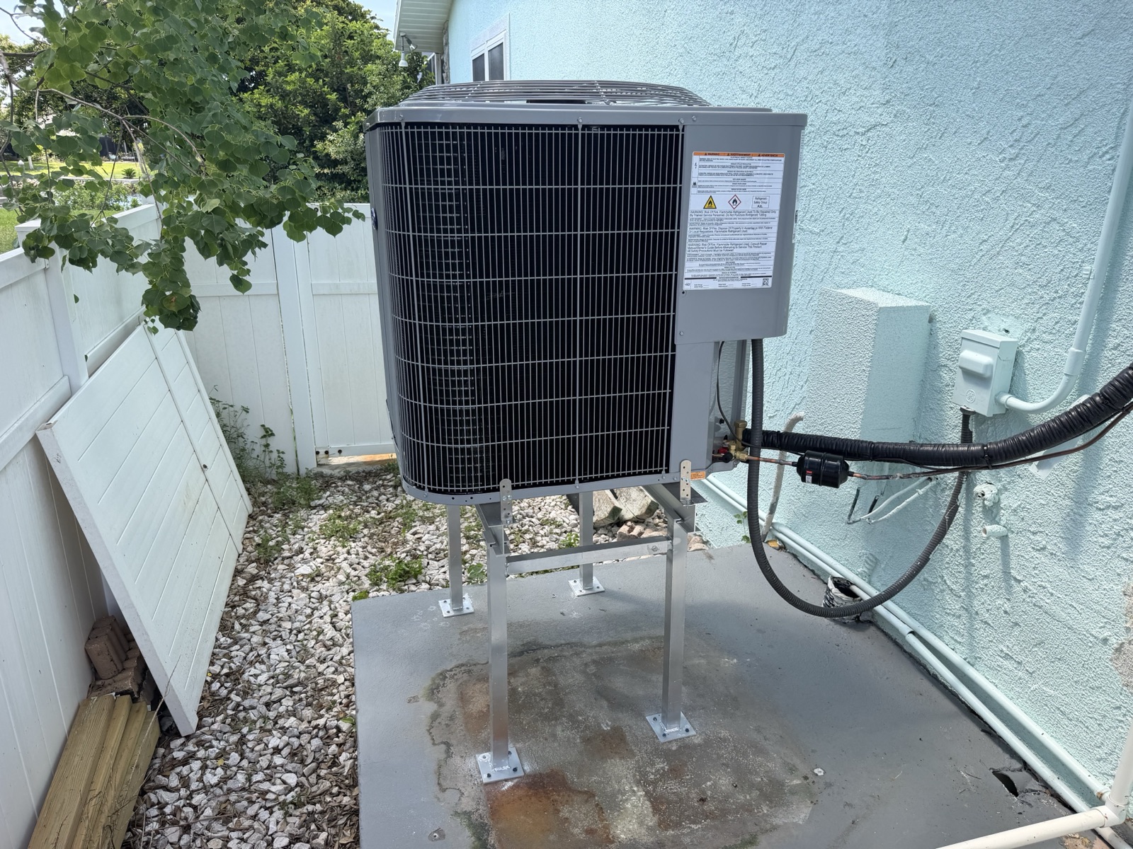 Newly installed outdoor air conditioner unit on an elevated stand beside a home in Homosassa, Florida